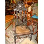 A pair of elaborately carved oak hall chairs (cane seats need replacing).