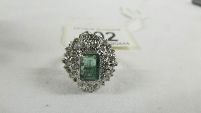 A 14ct white gold 1.75 emerald and 1.8 diamonds ring, size P.