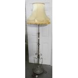 An early 20th century brass standard lamp with shade.