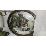 An oval mahogany framed bevel edged mirror.