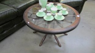 A Ship's wheel coffee table with glass top.