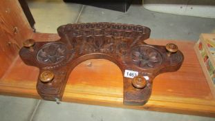 A carved wall mounting coat rack.