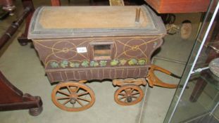 A large wooden toy horse drawn caravan.