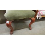 An Edwardian mahogany framed footstool with green dralon upholstery.