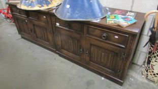 A pair of 2 door, 2 drawer oak cabinets.