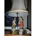 A good double porcelain figure table lamp on brass base, in good condition.
