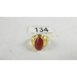 A ring set red stone, size T (tests as 24 ct gold).