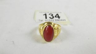 A ring set red stone, size T (tests as 24 ct gold).