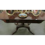 A good quality mahogany table with dropsides and on brass lion paw feet.