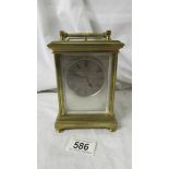 A late 19th century striking carriage clock with reverse painted on glass panels,