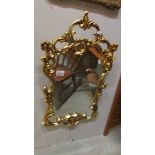 A gilded plastic framed mirror.