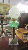 A Victorian brass column oil lamp with green glass font (burner converted to electric but font not