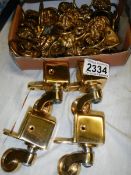 In excess of 40 brass lion head cabinet handles with drop loop and 4 new furniture casters.