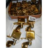 In excess of 40 brass lion head cabinet handles with drop loop and 4 new furniture casters.