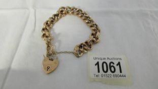 A gold bracelet with safety chain and padlock, 21.2 grams.