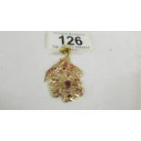 A stone set floral design pendant (tests as 24ct gold).