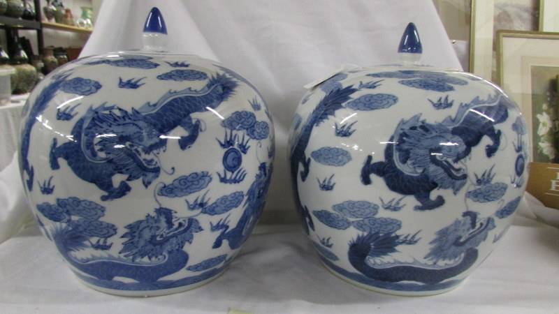 A striking pair of large blue and white lidded porcelain melon ginger jars with dragons chasing - Image 2 of 6