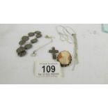 A silver necklace, a silver pendant on chain, a silver cross,