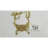 A necklace on long chain, (tests as 24ct gold) 30 grams.