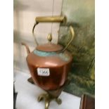 A copper kettle on a brass trivet,