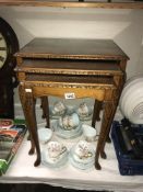 An Edwardian. nest of tables with figured walnut tops under glass.