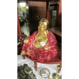 A gilded porcelain figure of Buddha.