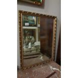 A bevel edged gilt framed mirror.