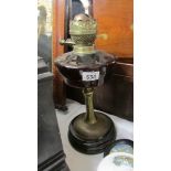 A Victorian oil lamp base with glass font and complete with burner.