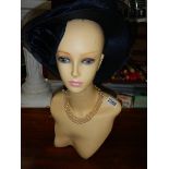 A manikin head with hat. ****Condition report**** Made of plastic.