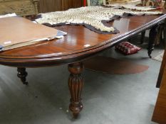 A large oval mahogany extending dining table.