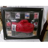 A framed signed boxing glove with signatures of Ken Norton, Leon Spinks, Ernie Shavers,