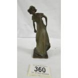 A small art nouveau hollow bronze figure of a lady bowler. 13 cm tall.