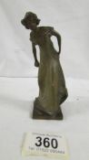 A small art nouveau hollow bronze figure of a lady bowler. 13 cm tall.