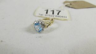 A 9ct gold diamond and blue topaz cluster ring in gold band, size J.