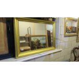 A large gilt framed bevel edged mirror.