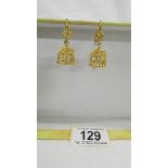 A pair of pendant earrings, (test as 24 ct gold) 8.8 grams.