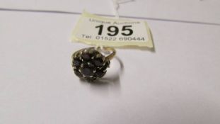 A 9ct gold and garnet round dress ring, size L.