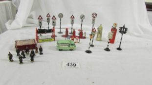 A quantity of die cast road signs, petrol pumps, Dunlop tyre rack and Dinky '00' gauge passengers.