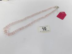 A rose quartz necklace with silver clasp.