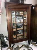 An Edwardian oak cabinet with bevelled mirror panels painted with milinary, Chicago advertising.