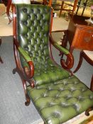 A mahogany framed green leather deep buttoned chair with matching footstool.
