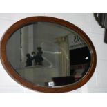 A mid 20th century oval oak framed bevel edged mirror.