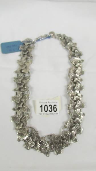 An unusual necklace designed as overlapping leaves in white metal.