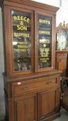 A glazed top cabinet with Reece & Son., lettering.