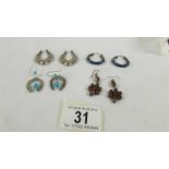 4 pairs of silver earrings.