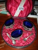 A cased set of 3 salts with blue glass liners.