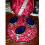 A cased set of 3 salts with blue glass liners.