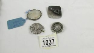 Three old brooches and a further brooch in white metal.