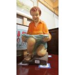 A large early 20th century painted plaster figure of a kneeling boy.