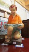 A large early 20th century painted plaster figure of a kneeling boy.